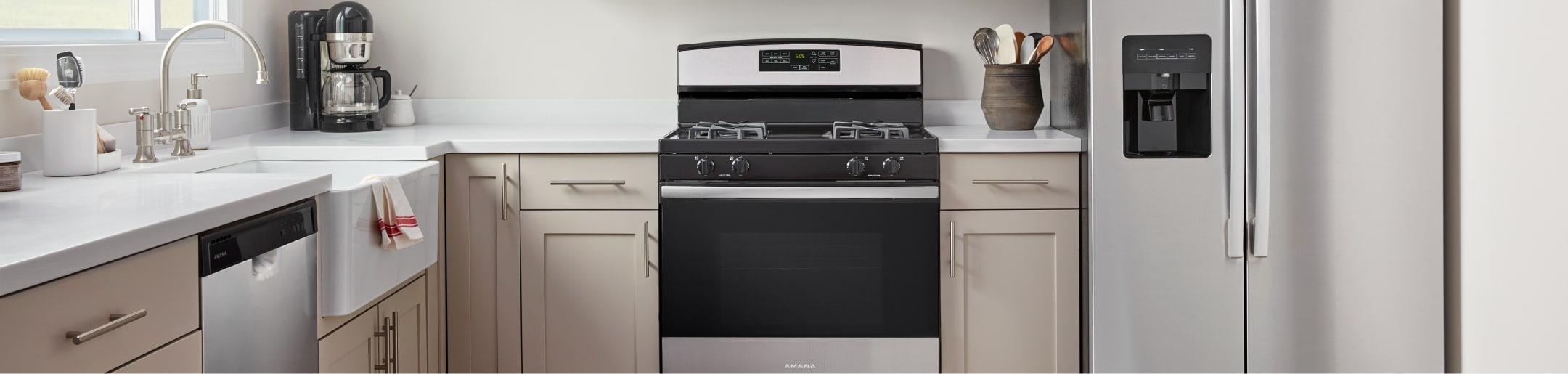 An Amana® dishwasher, range and refrigerator in a kitchen.