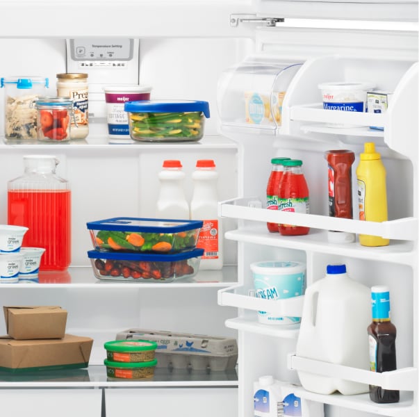 An open Amana® refrigerator with food inside.
