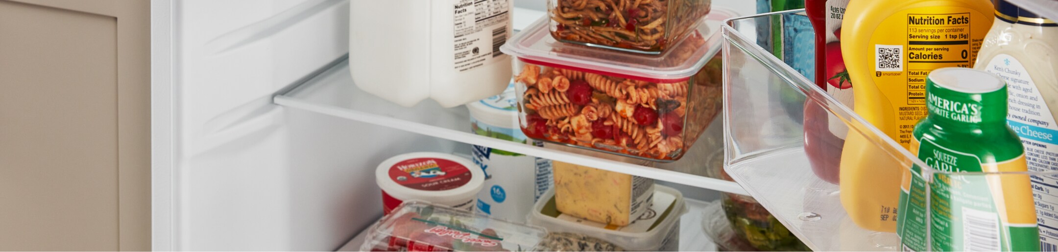 Food and various condiments in an Amana® refrigerator.