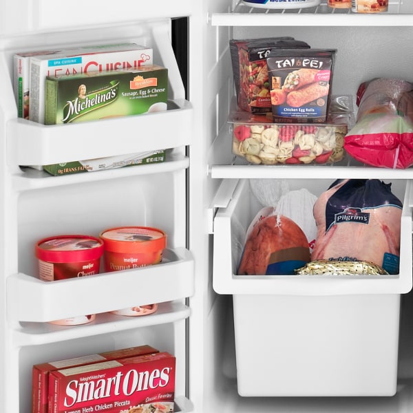 An Amana® refrigerator with food items inside.