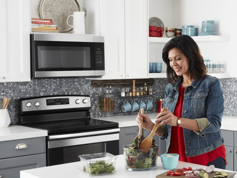 Woman making salad in a modern kitchen Woman making salad in a modern kitchen
