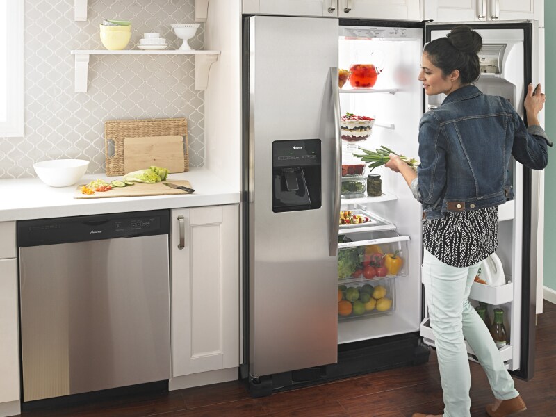 Person getting food out of Amana® refrigerator
