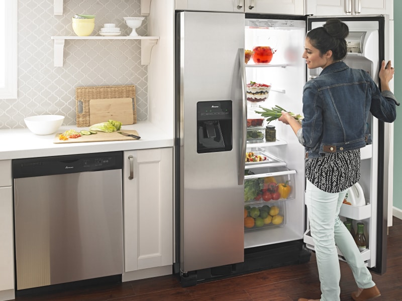 Person getting food out of Amana® refrigerator Person getting food out of Amana® refrigerator