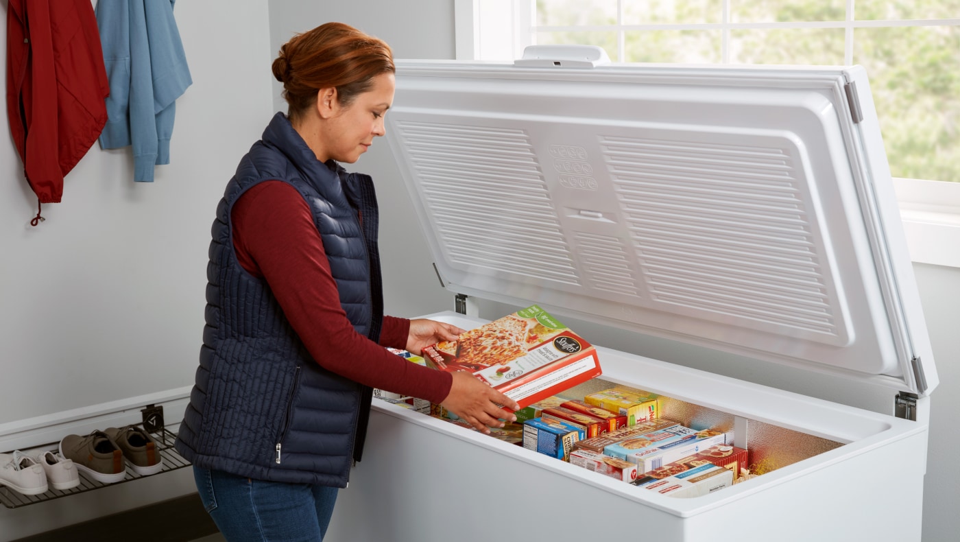 Person putting food in a chest freezer
