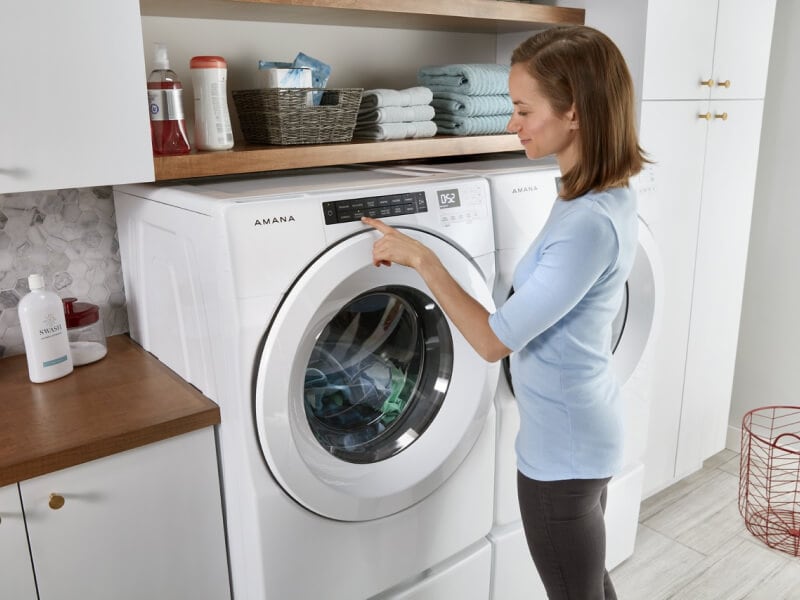 Person making a selection on a front load washing machine Person making a selection on a front load washing machine