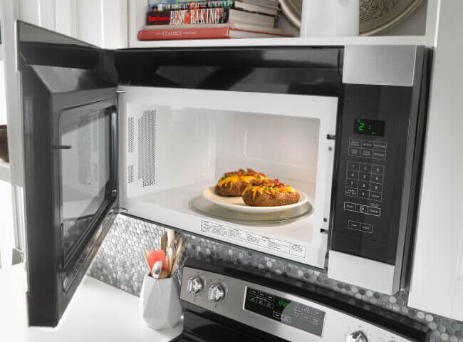 Amana® microwave with door open and food inside