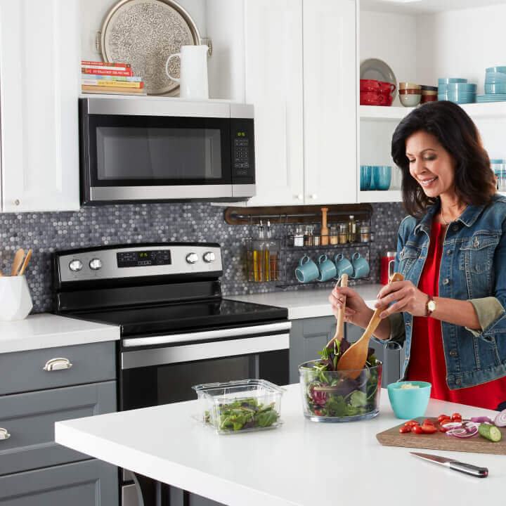 Person prepping food in a kitchen with Amana® kitchen appliances
