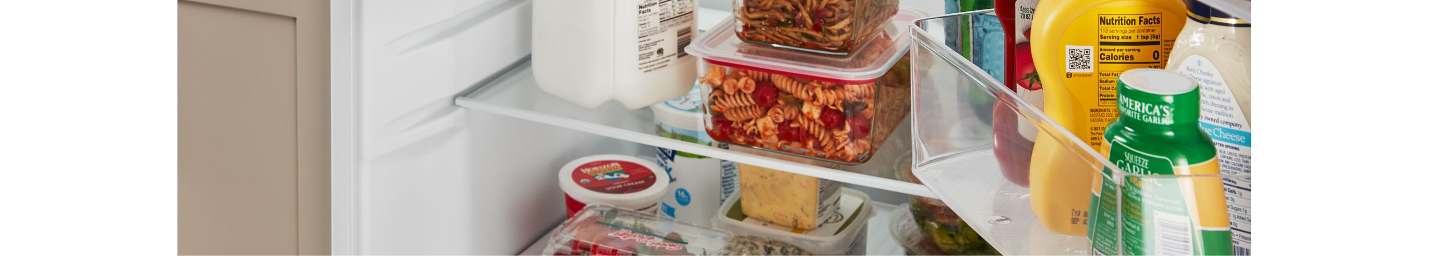 Food and various condiments in an Amana® refrigerator.