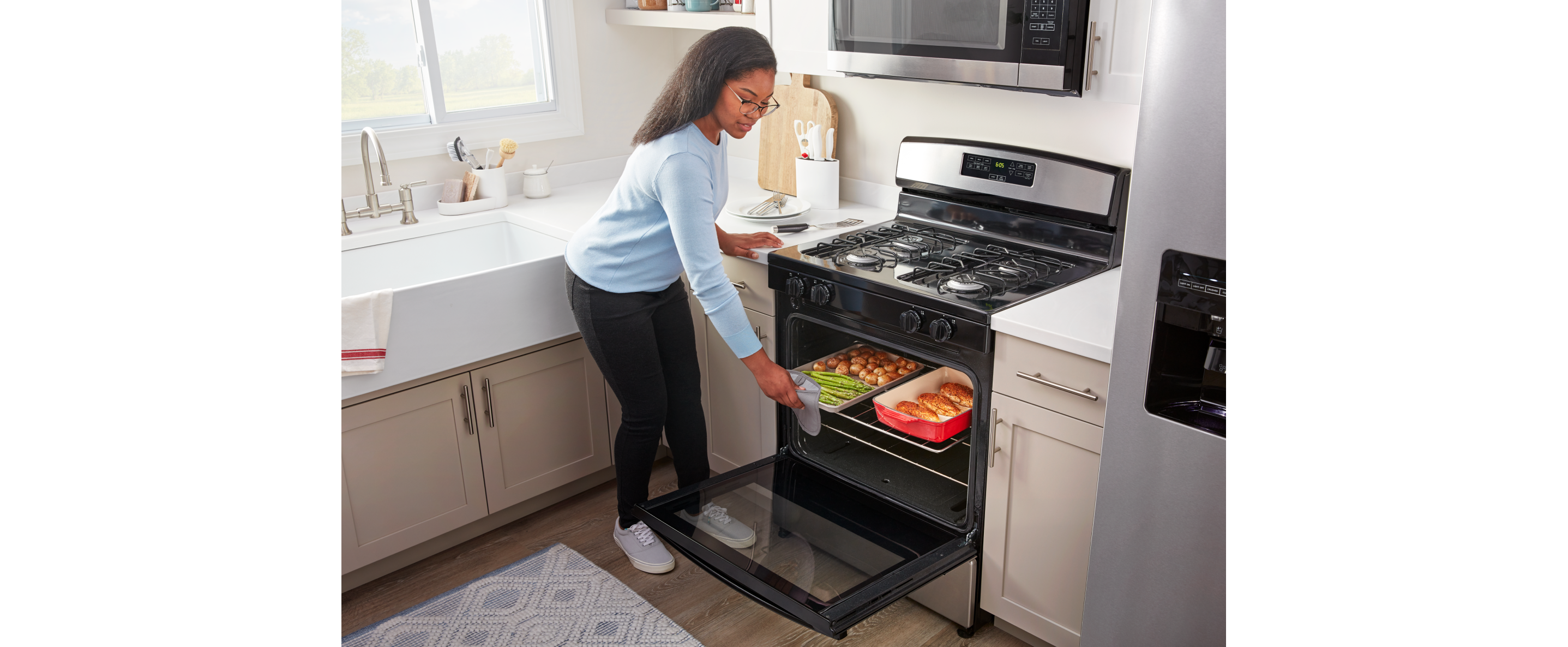 Person loading pans of food into an Amana brand oven